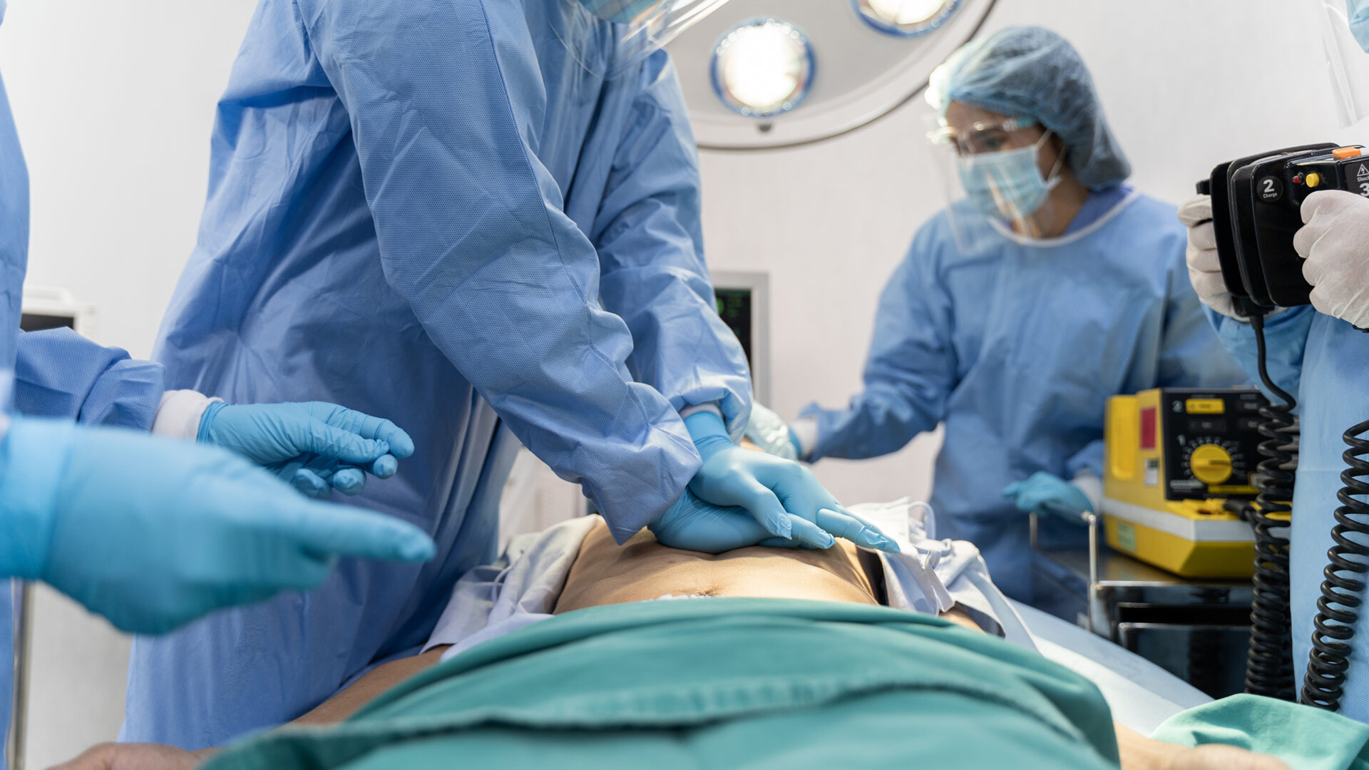 Medical Team In Surgical Gown Help Patient To Making CPR Cardio